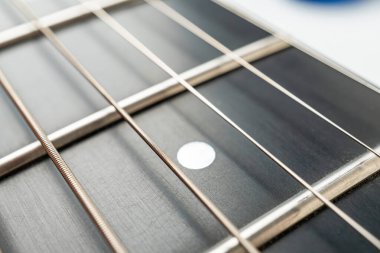 Yüksek çözünürlüklü resim akustik gitarlara odaklanıyor. Boyun ve fretboard, keskin detaylar sergiliyor. Açık renkli ahşap.