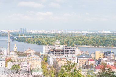 Hareketli şehrin ufuk çizgisi, kıvrımlı nehir, canlı şehir manzarası, yemyeşil yeşillik, botlar, yüksek gökdelenler, alçak yerleşim yerleri, berrak mavi gökyüzü, kentsel vaha, şehir hayat dinamikleri, seyahat dinamikleri