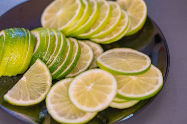 Görüntü, taze narenciye meyvelerinin canlı bir görüntüsünü sergiliyor. Limonlar ve limonlar, sulu bölümler keskin lezzetlerini ortaya koyuyor. Düzenleme, kaliteyi, tazeliği ve detaylara dikkat etmeyi gösteriyor.