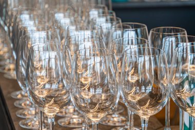 Karanlık, parlak bir masanın üzerinde düzgün düzenlenmiş şarap kadehleri, simetri açılı, yumuşak ışıklandırmayla yansıtılan gölgeler, insan varlığı veya metni yok basitlik ve zarafete vurgu, şerif