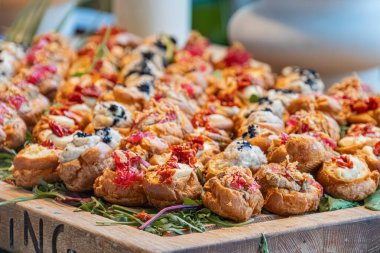 Tahta kesme tahtası, otlar, aperatifler tartlet, krem peynir, zeytin, otlar, canlı renkler, sıcak kahverengi tahta, doğal ışık, kapalı alan, metin yok, gerçekçi bir stil biraz yükseltilmiş