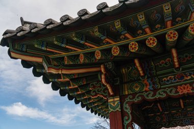 Geleneksel Kore Hanok 'u, eğri büğrü bir çatıda, arka planda ağaçlar ve yeşilliklerle donatılmış, arka planda zemin seviyesinden perspektifli, ağaçlarla çevrili, tarihsel olarak önemli tasarımlar.