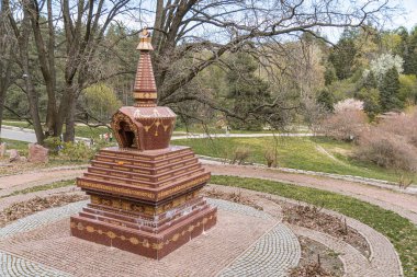 Karmaşık desenli dairesel taş stupa, bir parkta ya da açık havada konumlandırılmış muhtemelen manevi ya da kültürel önemi olan dekoratif tasarım Concentric Kyiv, Ukrayna 04-19-2025