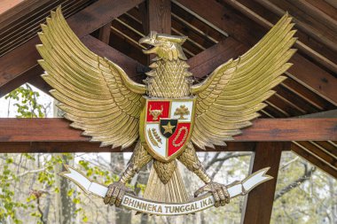Altın Heraldik kartal amblemi kalkanla, çapraz kılıçlarla, gerçekçi stil, yumuşak ışıklandırma, zengin ılık renkler, açık hava ayarı Kyiv, Ukrayna 04-19-2025