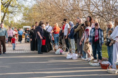 Paskalya ve yumurta kutsanması, manastırın yakınındaki peştamada, rahip cemaate kutsal su serpiyor. - Kyiv, Ukrayna 04-19-2025.