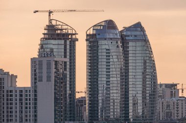 Ukrayna, Kyiv, 04-19-2025 yılının aydınlatma modern tasarım ve altın saatin sergilendiği, yüksek binaların inşa edildiği şehir manzarası