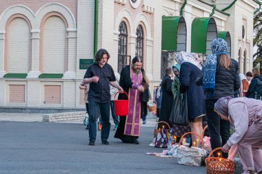 Paskalya ve yumurta kutsanması, manastırın yakınındaki peştamada, rahip cemaate kutsal su serpiyor. - Kyiv, Ukrayna 04-19-2025.
