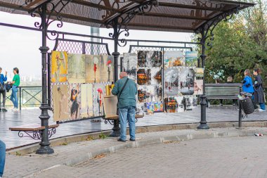 Dış mekan, tuğla yol, siyah dövmeli demir çatılı metal çardak ve açık kenarlı boyalı sanat eserleri tribünlerin içinde ya da sehpalarda Kyiv 'de, Ukrayna' da 10-11-2024