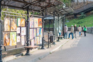 Açık hava kaldırımı, dekoratif elementlere sahip metal yapı, gölge örtüsü, şövaleler, yayalar, günlük kıyafetler, Kyiv, Ukrayna 10-11-2024 'ten sonra gün ışığı.