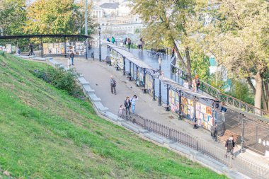 Merkezi merdiveni olan hareketli bir park, gündelik giysiler içinde çeşitli bireyler, yükselen merdivenler, aktiviteler, son bahar etkinlikleri, Kyiv, Ukrayna 10-11-2024