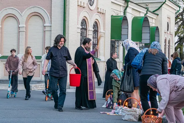 Paskalya ve yumurta kutsanması, manastırın yakınındaki peştamada, rahip cemaate kutsal su serpiyor. - Kyiv, Ukrayna 04-19-2025.