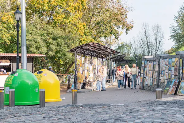 Açık hava ayarı, güneşli bir gün, renkli sanat eserleriyle kaplı kabin veya tezgah, insanların göz gezdirmesi veya yürümesi, kabin, şehir parkı veya kamusal alan etkileşimi, t Kyiv, Ukrayna 10-11-2024