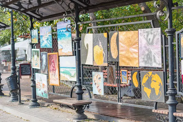 Tahta bank, siyah metal korkuluklar, bankın arkasında renkli posterler, canlı renkler, gündüz aydınlatma, B Kyiv, Ukrayna 10-11-2024 'te olası yemek tezgahı veya oturma alanı