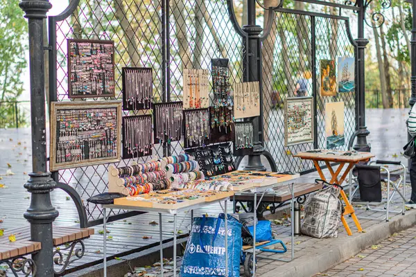 Açık hava sanat pazarında çeşitli renkli resimler, fotoğraflar ve el sanatları ürünleri halka açık bir alanda, Ukrayna 'nın Kyiv, 10-11-2024' te masalarda sergilenmektedir.