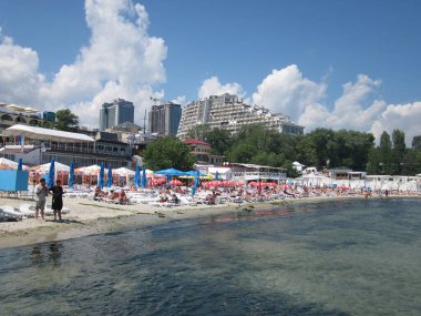 Güneşli sahil sahnesi, insanlar, şemsiyeler, sakin bir sahil kenarı olan Odessa, Ukrayna 06-03-2012