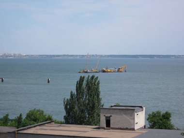 Gündüz vakti sağlam küçük bir ev, demirli tekneler, endüstriyel vinç, bulutlu gökyüzü, sessiz renkler ve Odessa, Ukrayna, 06-15-2012 ışıklandırması ile rıhtım sahnesi