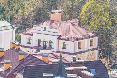 Kırmızı kiremit çatılı, beyaz aksanlı ve klasik mimari öğeleri olan iki katlı Avrupa binası, sabahın erken saatlerinde ya da öğleden sonra açık gökyüzüne karşı kurulmuştur.