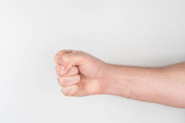Odaklanmış, kısmen uzatılmış bir kol ve sessiz bir arka plana karşı sıkılmış bir yumruk.