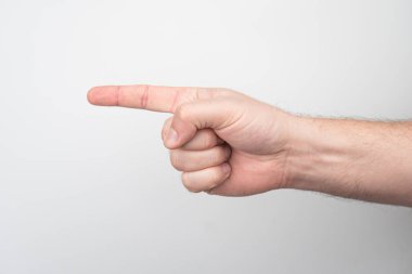 Açık tenli, işaretsiz bir kolun yakın çekimi, işaret parmağı kapalı mekan aydınlatmasını işaret ediyor, gizli fotoğraf tarzı, aşağıdan yukarıya bakan perspektif