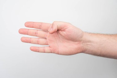 Açık tenli, parmak kıvrımlı bir insan elinin doğal ışıklandırmanın oluşturduğu yumuşak gölgelerle nötr bir arka plana yakın plan.