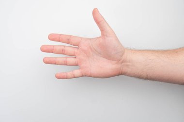 Yatay kol uzantısına yakın plan, yukarı bakan el, hafifçe vurgulanmış tendonlar ve kaslar, bulanık arka plan, nötr tonlar