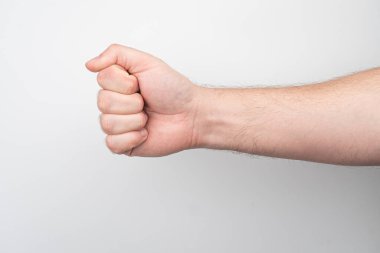 Genişletilmiş kol, açık ten, çiller, sıkılmış yumruk, azim veya güç hareketi, sığ alan derinliği, tanımlanamayan arka plan, hatta ışıklandırma.