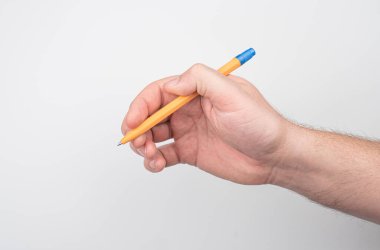 Açık bir yüzey üzerinde mavi bir kalem tutan bir elin yakın plan resmi, muhtemelen bir duvar ya da tahta, basitliğe odaklanmış gerçekçi bir metin yok