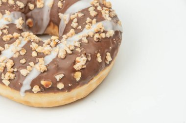 Beyaz ve çikolata jöleli donut, fındık ve granola dokulu yüzey, hafif arka plan, hafif ışıklandırma, perspektifin biraz üzerinde