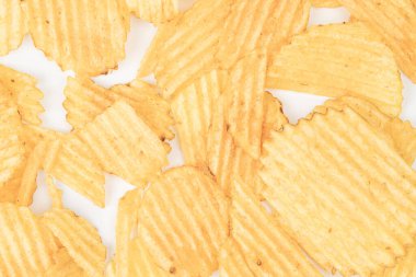 Beyaz masa ya da tezgahta sarı fırında patates cipsi koleksiyonu, değişik boyutlarda ve şekillerde Ruffles-benzeri, metin yok, hatta ışıklandırma bile, gelişigüzel belgesel tarzı