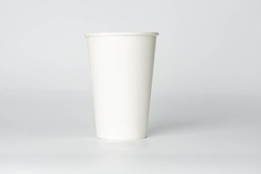 Yansıtıcı yüzeyde açık kapaklı beyaz kağıt bir kahve fincanı, basit tasarım, yumuşak gölgeler, hatta ışıklandırma.