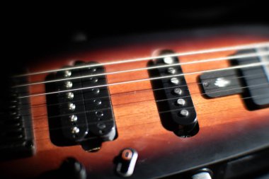 Elektro gitarın yakın çekimi, koyu kahverengi renk tonu, parlak bitiş, metal perdeli ahşap parmaklık görünür, gölge fretboard aydınlatma, metin yok veya insanlar
