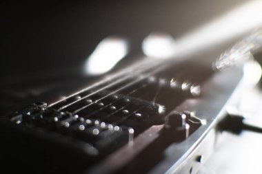 Elektro gitar fretboard yakın çekim, sicimler ve keskin odaklı arka plan bulanık tonlar karşı soğuk mavi, siyah egemen, doğal ışık yumuşak bir parıltı oluşturan