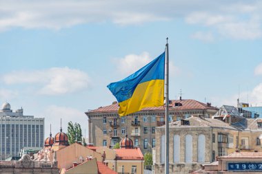 Ukrayna ulusal bayrağı sallanıyor. Bulanık binaları olan güzel bir direk. Bağımsızlık Günü için Ukrayna ulusal bayrağı.