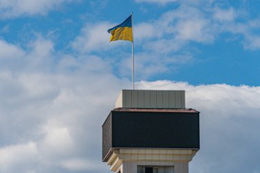 Ukrayna ulusal bayrağı sallanıyor. Bulanık binaları olan güzel bir direk. Bağımsızlık Günü için Ukrayna ulusal bayrağı.