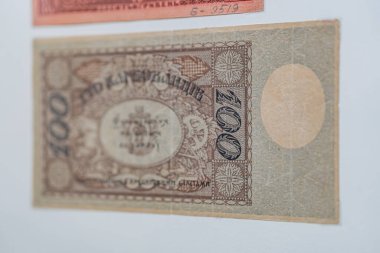 Tarihsel, yaşlanmış Ukrayna banknotu bir yüzeye yapıştırılmış mavi, yeşil, mor ve sarı renkte bir portre ve karmaşık desenler hem sol hem de sağ tarafta natura altında 3 boyutlu bir etki gösteriyor