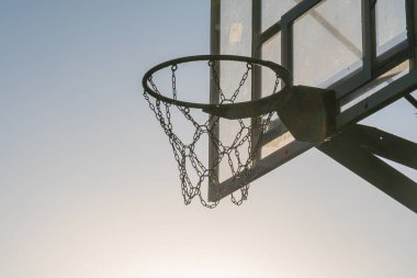 Açık havada, gün ışığında, basketbol maçında, arka tahtada metal halka zincirli ağ, beklenti, gol alanı tarzında, aksiyon odaklı...