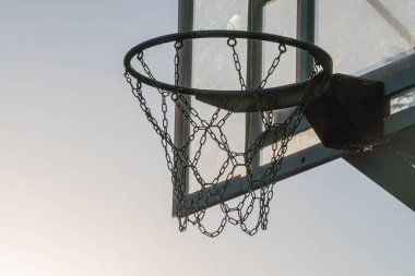 Arka tahtası, metal halkası ve zincirleri olan açık hava basketbol potası, cam veya akrilik sedye.