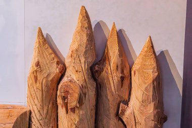 Dört farklı ahşap heykel, eşsiz tasarımlar, duvar arkaplanı, yumuşak gölgeler, açık renkli zemin, yakın perspektif