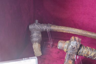 Sergi setinde iki adet tarihi eser sergileniyor. Tarih öncesinden kalma büyük bir metal obje ve modern bir iletişim teknolojisi cihazı. İkisi de koyu kırmızı bir vitrin kutusuna yerleştirilmiş.