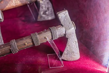 Müze ortamında sergilenen antika ateşli silah, karmaşık ahşap oymalar ve cilalanmış metal detaylarıyla bulanık arka plana karşı yakın plan, kimlik tespiti için yumuşak ışıklandırma ve