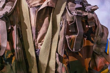 Kamuflaj desenli asker üniforması, sırt çantası, hafif açılı ışıklandırma, izole edilmiş şahıs.