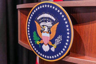 Üzerinde kartal, E Pluribus Unum sloganı, kalkan, yıldız çizgileri deseni, bohçalı oklar, zeytin dalı, bulutlar, yumuşak gölge, resmi tarz, insan yok