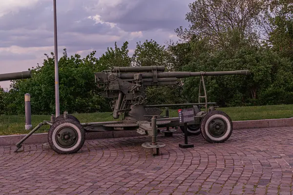 Tekerlekli taşıma aracındaki antika bir askeri top, tarihi bir ortamda yer almaktadır. Topun uzun bir namlusu vardır, sağlam metal bir vagonun tepesine büyük tekerlekleri vardır.