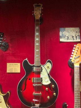 Kırmızı gitarın dört kontrol düğmesi, iki pikapı ve koyu renkli bir yüzeyde bir pikap anahtarı, muhtemelen bir masa ya da bir vitrin Backgroun Kyiv, Ukrayna 06-19-2022