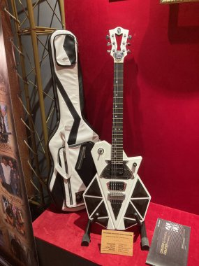 Eşsiz bir elektro gitarın yakın plan görüntüsü yaratık kafası şeklinde, ağırlıklı olarak siyah aksanlı, kırmızı arkaplan üzerinde gitar uzun bir n Kyiv, Ukrayna 06-19-2022 içeriyor.