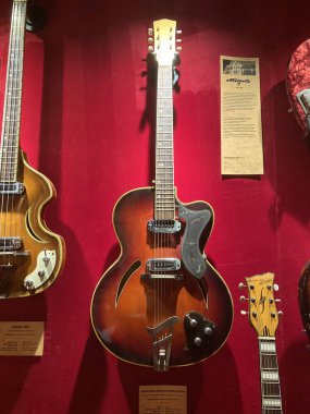 Üç akustik gitar, güneş patlaması bitiş merkezi, beyaz plaklar, kırmızı kumaş arka plan, yumuşak ışıklandırma, sıcak ortam Kyiv, Ukrayna 06-19-2022