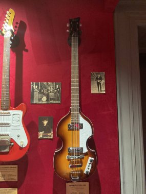 Klasik veya nadir müzik aletleri, ağırlıklı olarak gitar ve bas gitar, bir sergi alanında veya mağaza Kyiv, Ukrayna 06-19-2022 'de kırmızı kadife paneller üzerinde düzenlenmiştir.