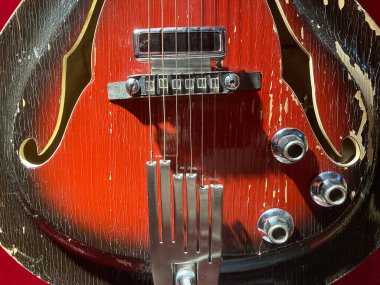 Kırmızı ve siyah elektro gitarın yakın plan görüntüsü, metalik donanım bileşenlerine odaklanmış, raptiyeler, köprü Kyiv, Ukrayna 06-19-2022