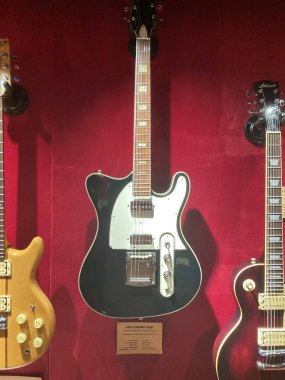 Dükkan ya da sergi alanında çeşitli gitar koleksiyonları, öne çıkan gümüş elektro gitar siyah pikapları, ön plandaki düğmeler Ro Kyiv, Ukrayna 06-19-2022