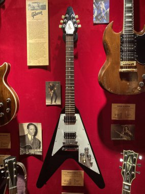 Kırmızı halı yüzeyi üzerinde dizayn ve bitirme çeşitliliğine sahip elektro gitar koleksiyonu, merkezi gitarın açısal gövdesi Stratokste Kyiv, Ukrayna 06-19-2022 'ye benzer.